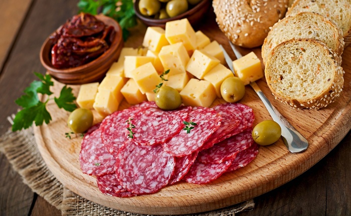 Charcuterie board with cheese, salami, olives, and bread