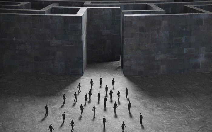 People entering a dark stone labyrinth