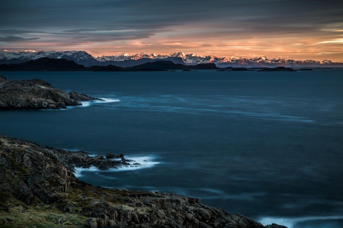 Rocky coastline with mountains and ocean at sunset