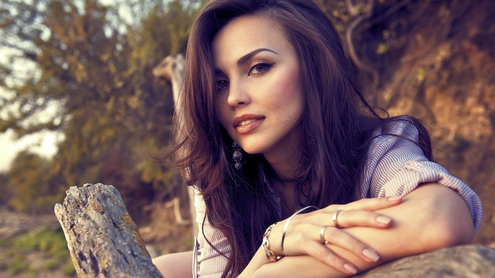 Woman with long brown hair and jewelry