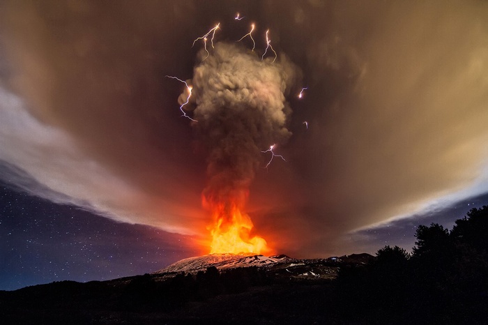 Volcano erupting with lightning and lava at night