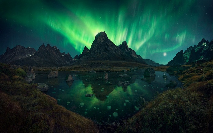Aurora Borealis over mountains and lake