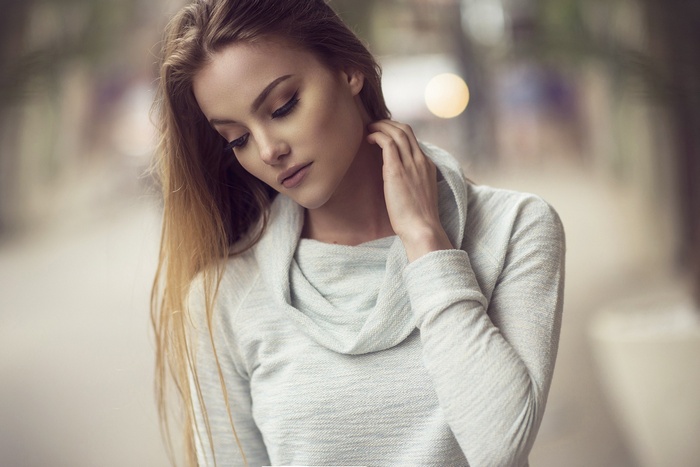 Woman with long blonde hair wearing a light blue sweater
