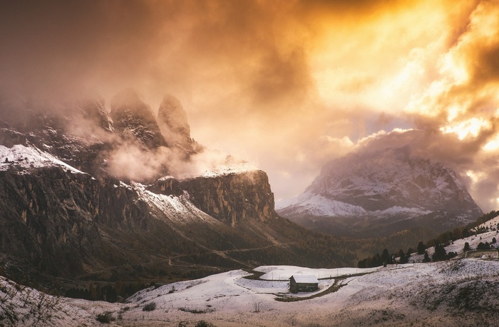 Winter cabin in the Italian Alps with dramatic clouds