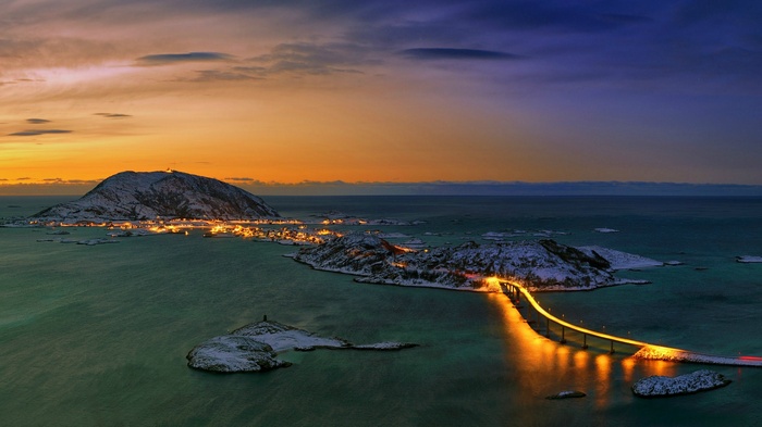 Bridge connecting islands with town lights at sunset in Norway