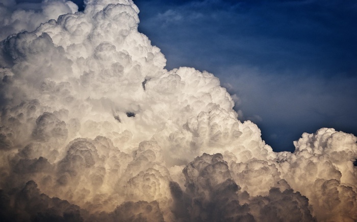 Cumulonimbus clouds against a dark blue sky