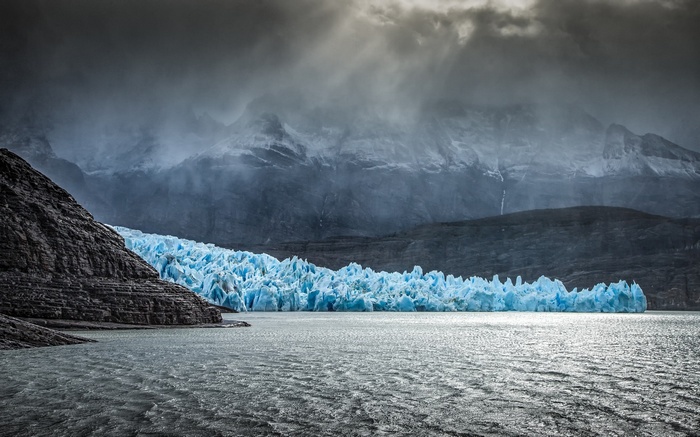 Grey clouds over a bright blue glacier in Patagonia, Chile