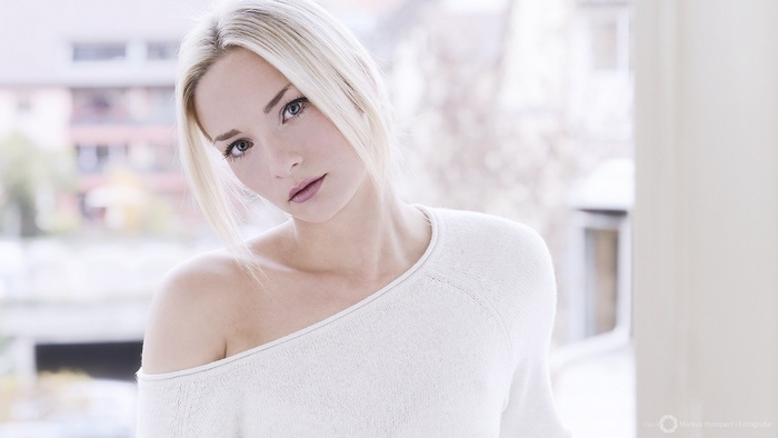 Woman with blonde hair wearing a white sweater