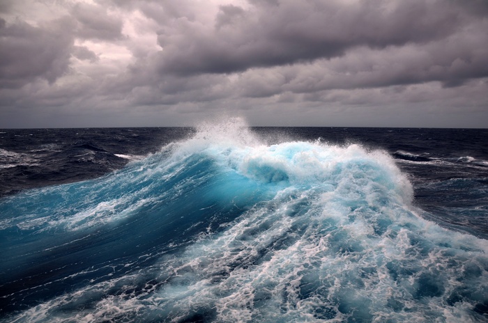 Crashing ocean waves under a cloudy sky