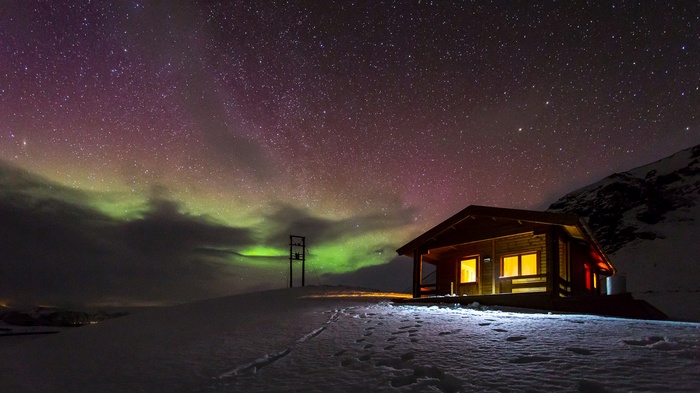 Cabin under the Aurora Borealis in the snow