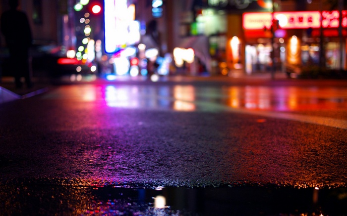 Wet city street at night with neon reflections