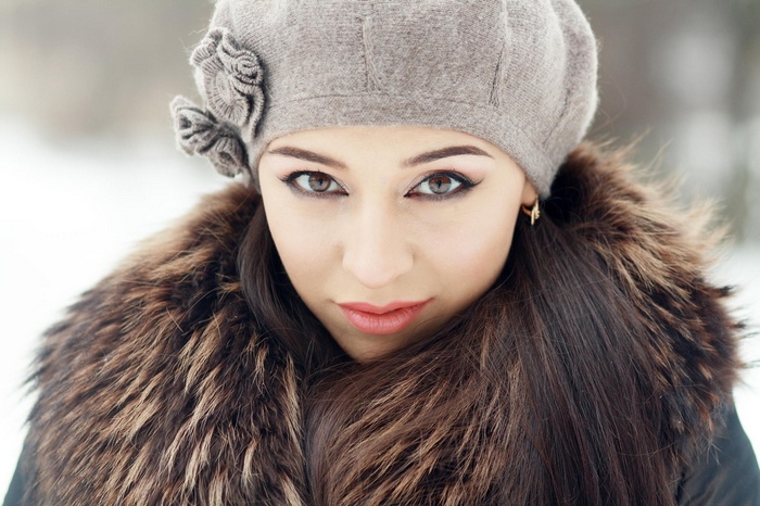 Woman in a fur coat and hat looking at the camera