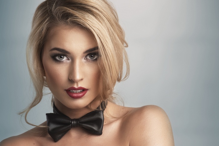 Woman with blonde hair and a black bowtie