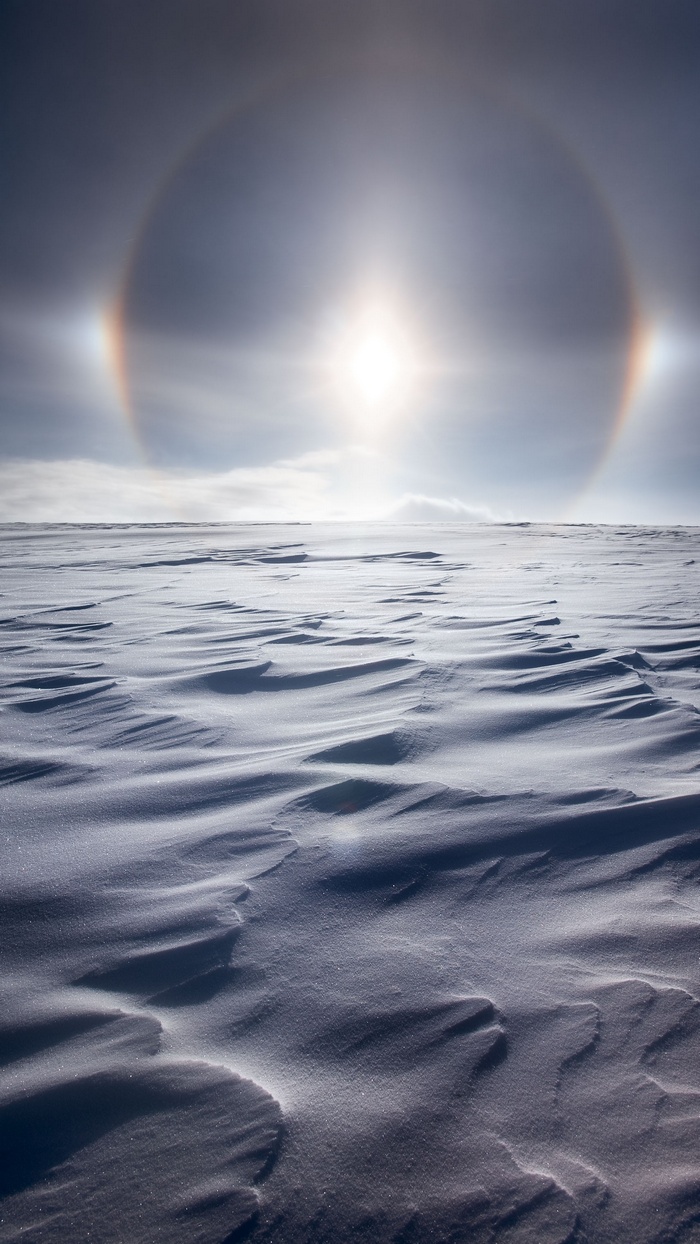 Snowy landscape with sun halo and parhelia