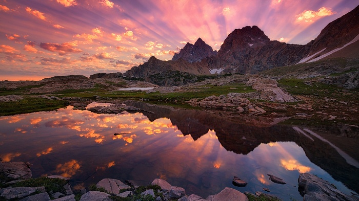 Mountain peaks reflected in a calm lake at sunset