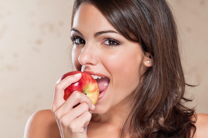 Woman eating a red apple