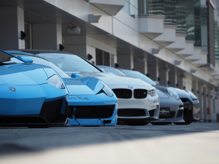 Blue Lamborghini, BMW, and other sports cars lined up