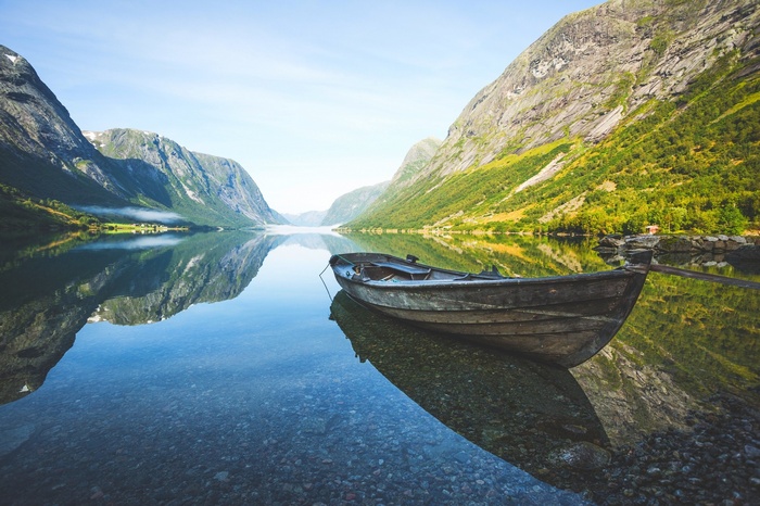 Boat on a calm fjord in Norway with mountains