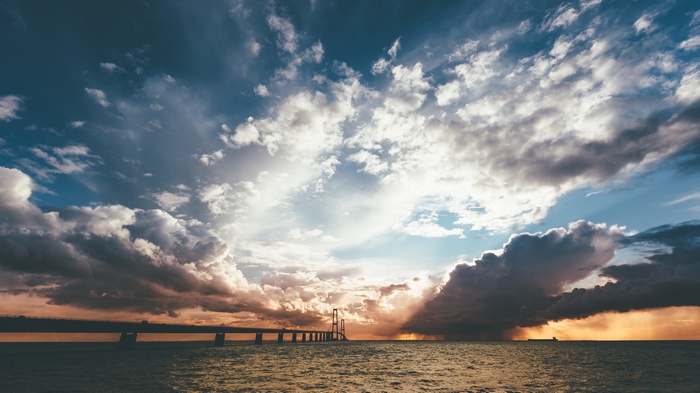 The Great Belt Bridge in Denmark over the sea with dramatic clouds