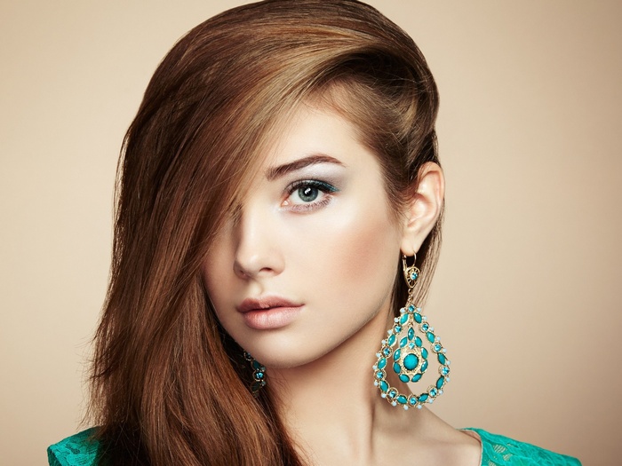Woman with long brown hair and large turquoise earrings