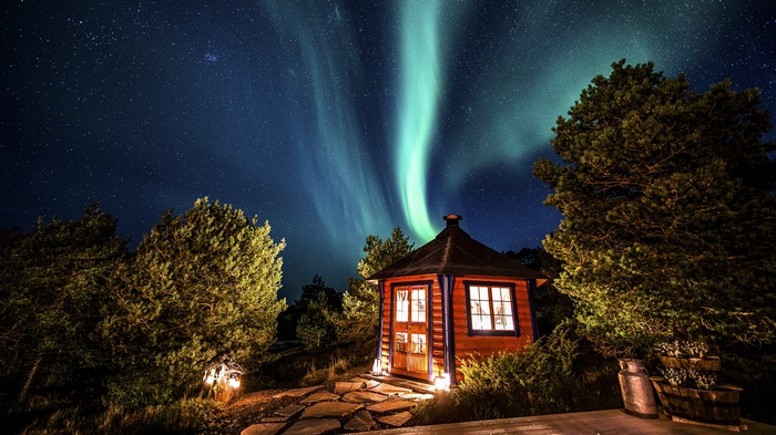 Wooden cabin under the Aurora Borealis