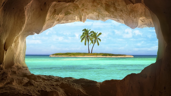 Island with palm trees seen from a cave