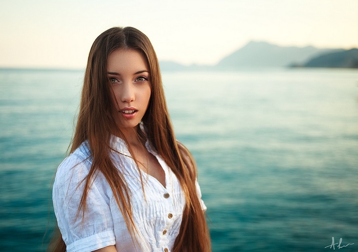 Woman in white shirt by the sea