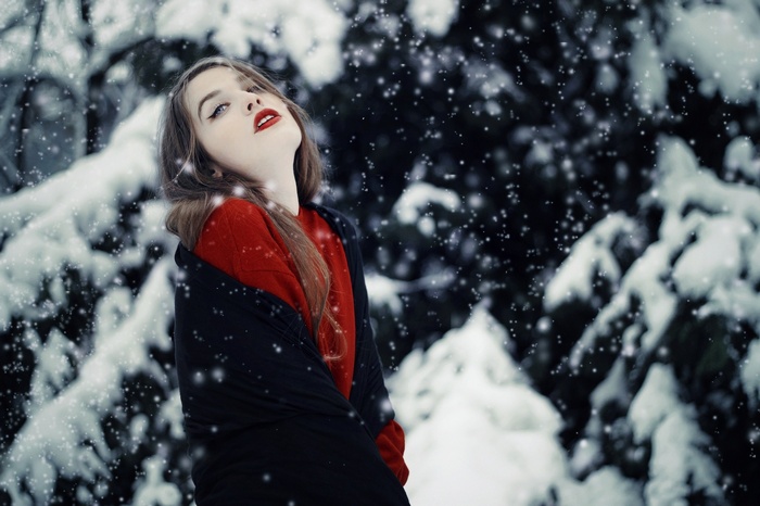 Woman in red sweater in snowy forest