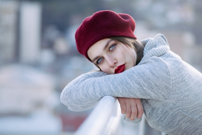 Woman wearing a red beret and grey sweater