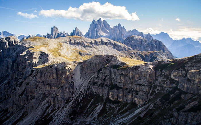 Rocky mountain peaks under a blue sky with clouds