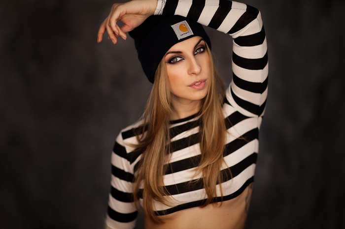 Woman wearing a black Carhartt beanie and striped shirt