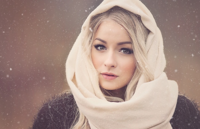 Woman with blonde hair wearing a scarf in the snow