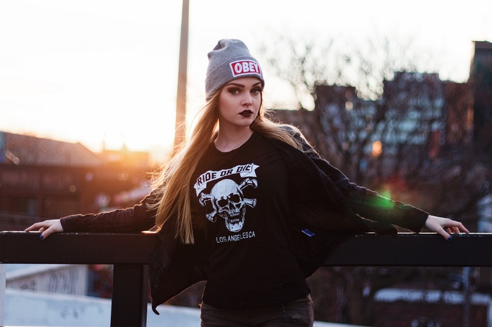 Woman wearing a beanie and a skull t-shirt at sunset
