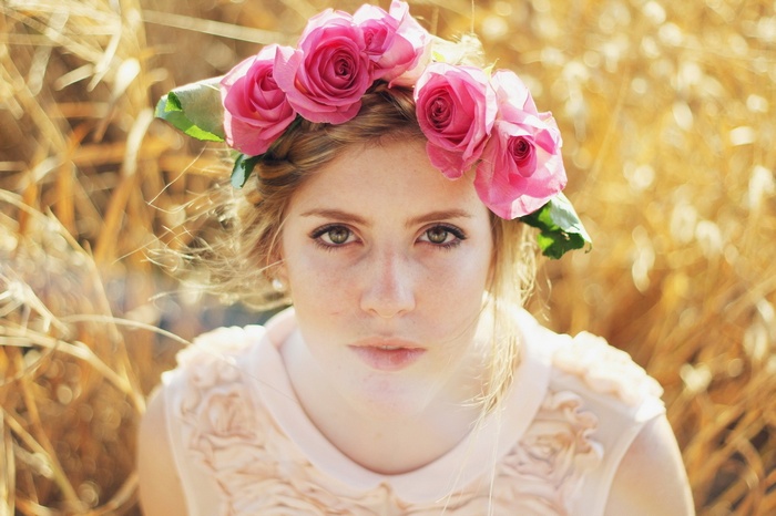 Young woman with a flower crown in a field