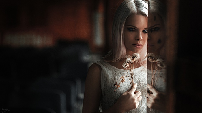 Masha Sidorova with flowers in front of a reflection