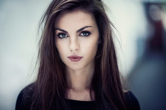 Brunette woman with freckles looking at the camera
