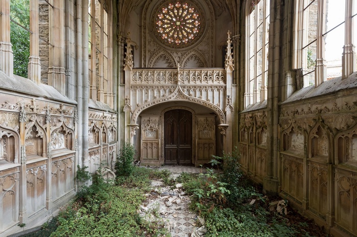 Abandoned Gothic church interior with overgrown plants