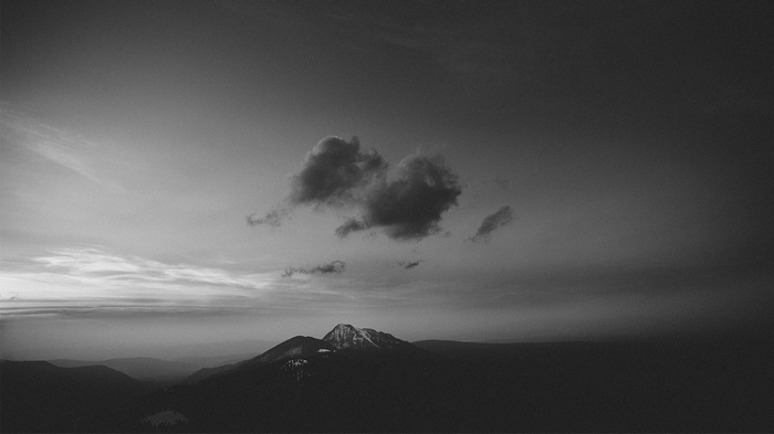 Dark clouds over a snow-capped mountain landscape