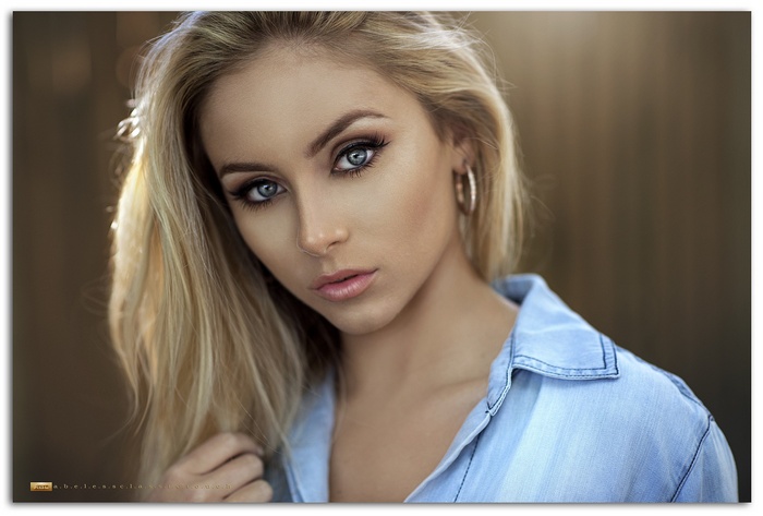 Blonde woman with blue eyes wearing a denim shirt