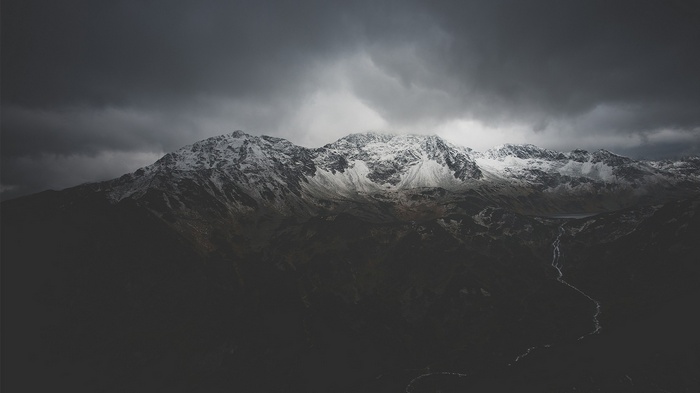 Snow-capped mountains under a cloudy sky