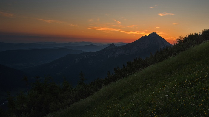 Mountain landscape at sunset with orange sky