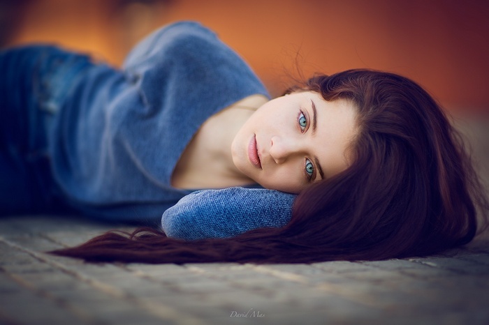 Brunette woman with blue eyes lying down