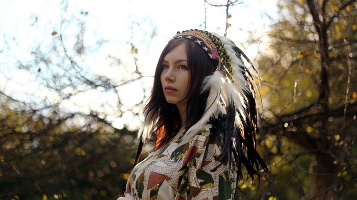 Woman with a Native American headdress in nature