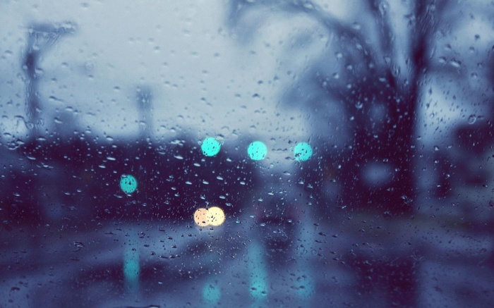 Rainy day bokeh lights through a wet window