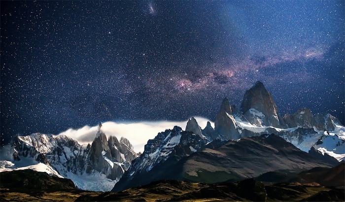 Mountain peaks under a starry night sky