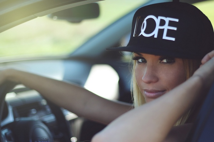 Woman wearing a black baseball cap with "DOPE" text