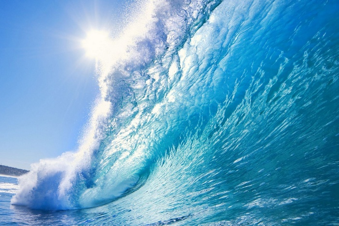 Sun shining on a powerful ocean wave