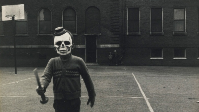 Boy in skull mask holding a baseball bat