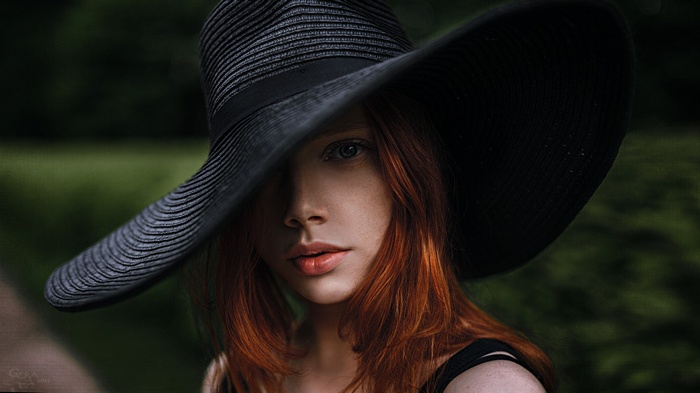 Woman with red hair wearing a black hat