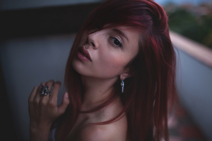 Portrait of a young woman with red hair and piercings